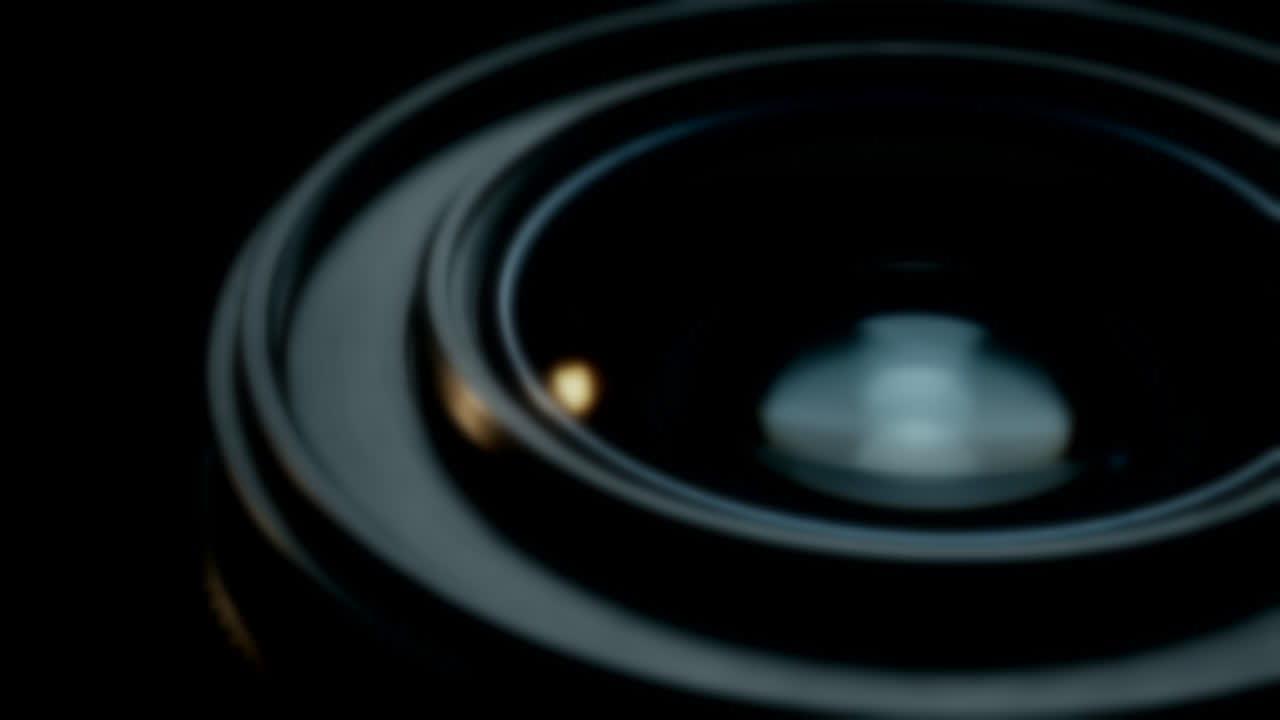 Macro view orbiting a precision camera lens catching a thin rim of light